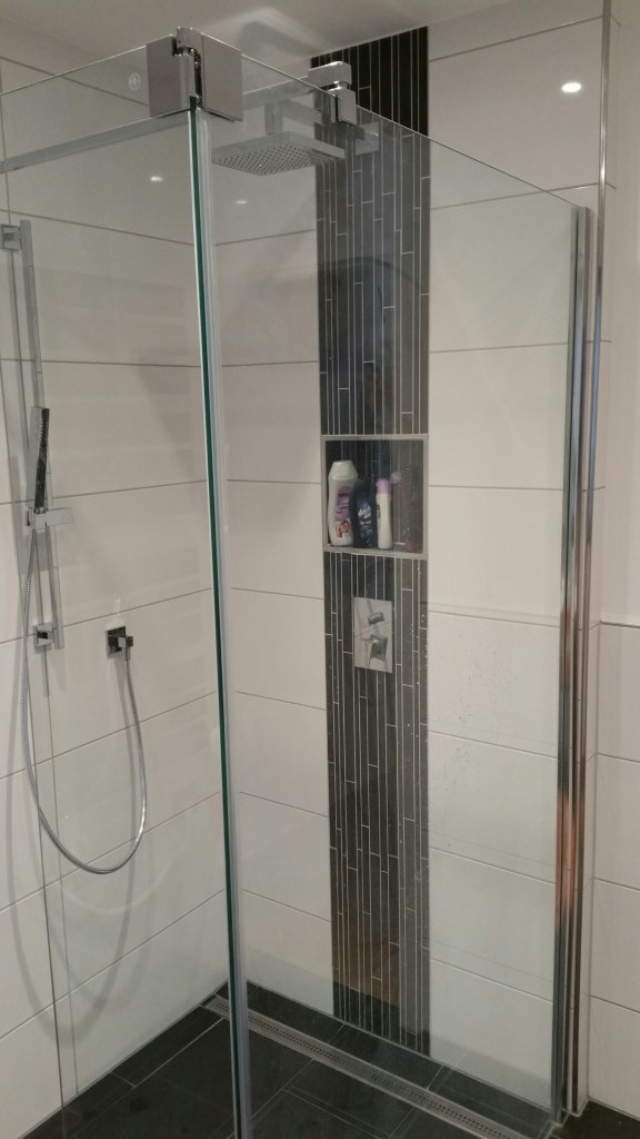 Moderne Dusche, ohne Duschtasse modern bodentief gefliest mit Duschabtrennung aus Glas und Armaturen in Chromoptik
